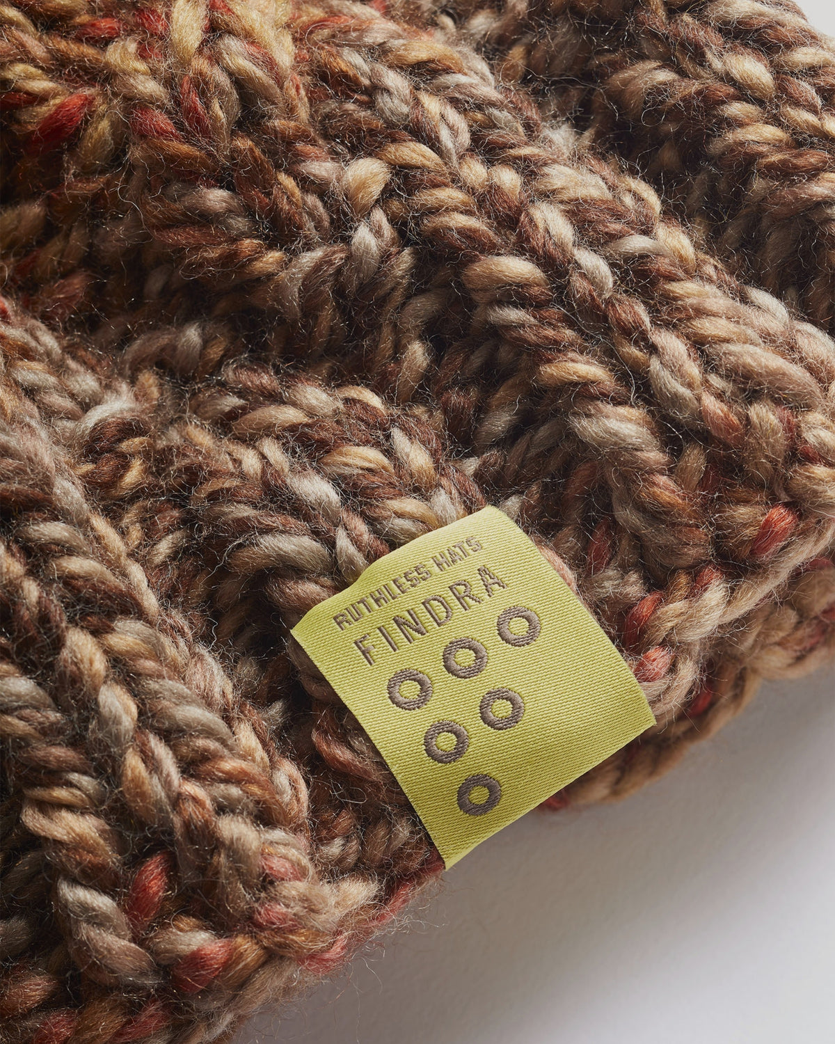 Close-up of a knitted item with a yellow label on a white background