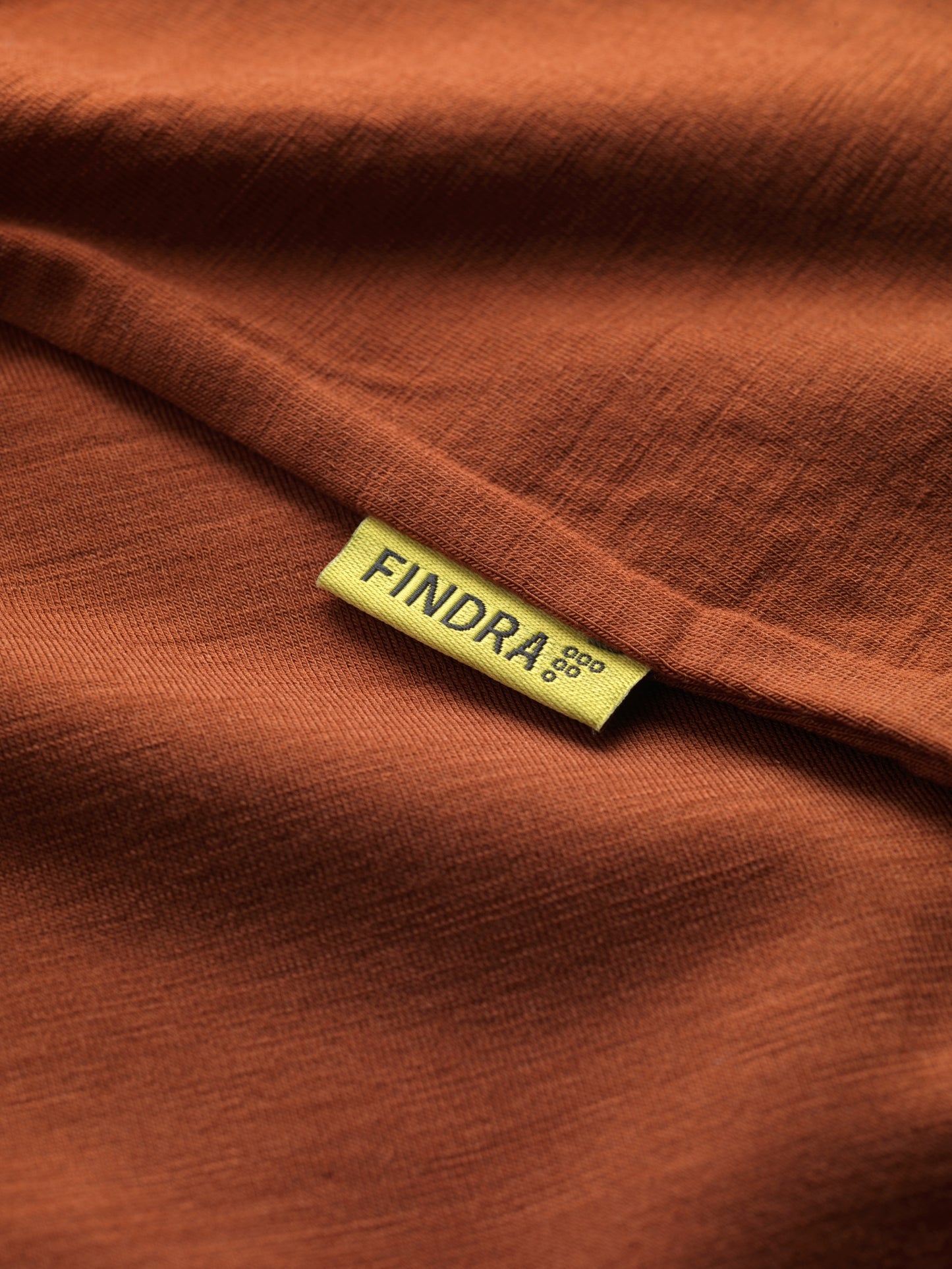 Close-up of amber fabric with a yellow 'FINDRA' label.