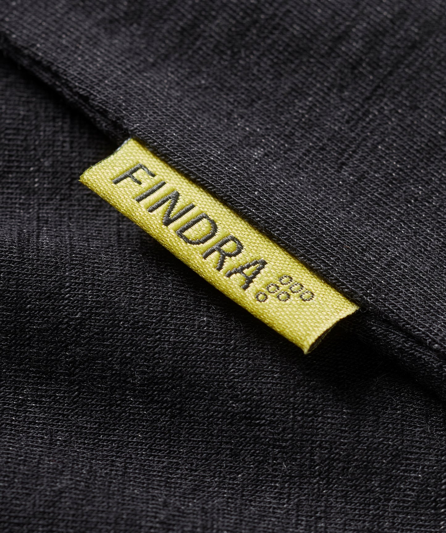 Close-up of a black fabric with a yellow 'FINDRA' label.
