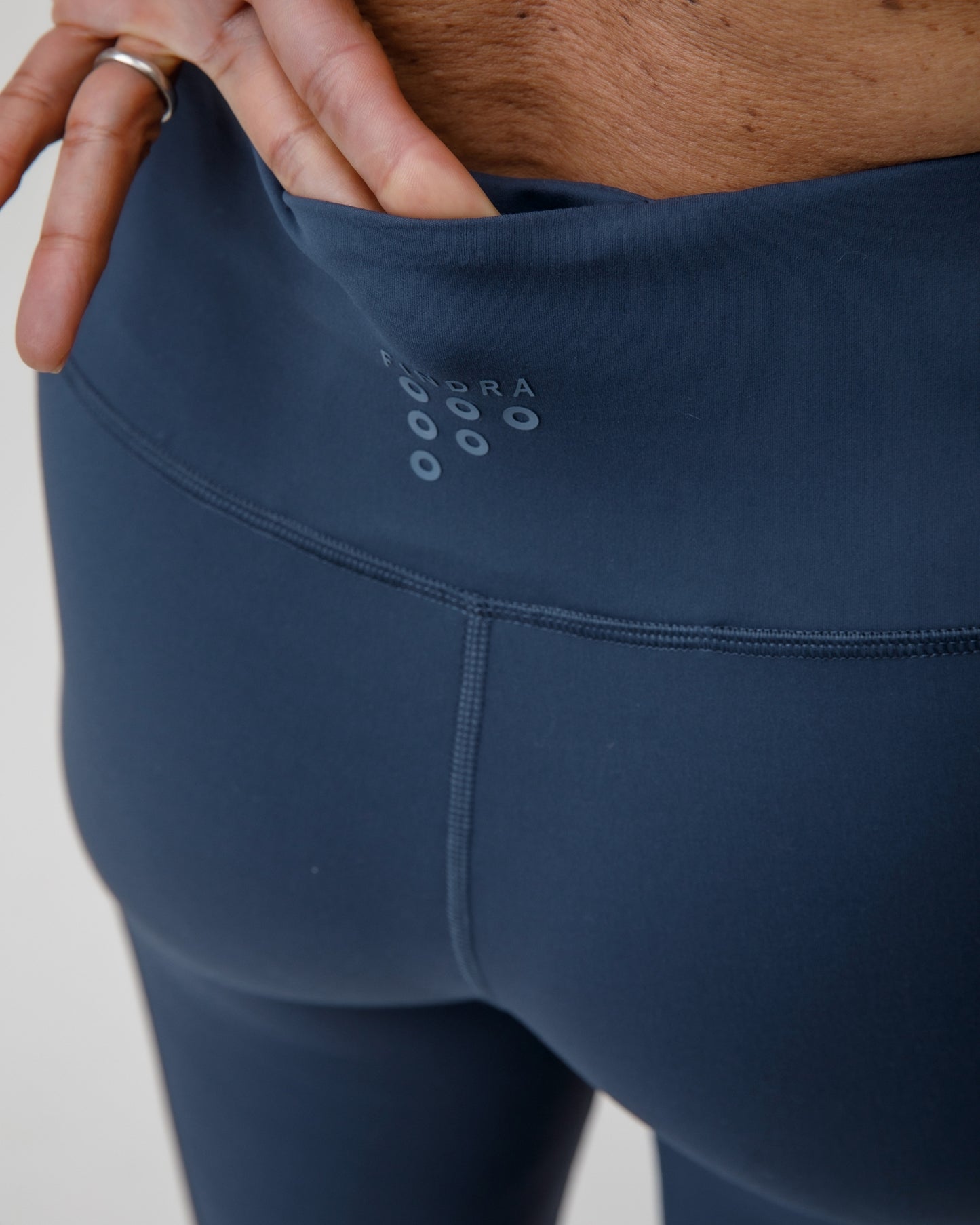 Navy leggings with a brand logo on a plain background