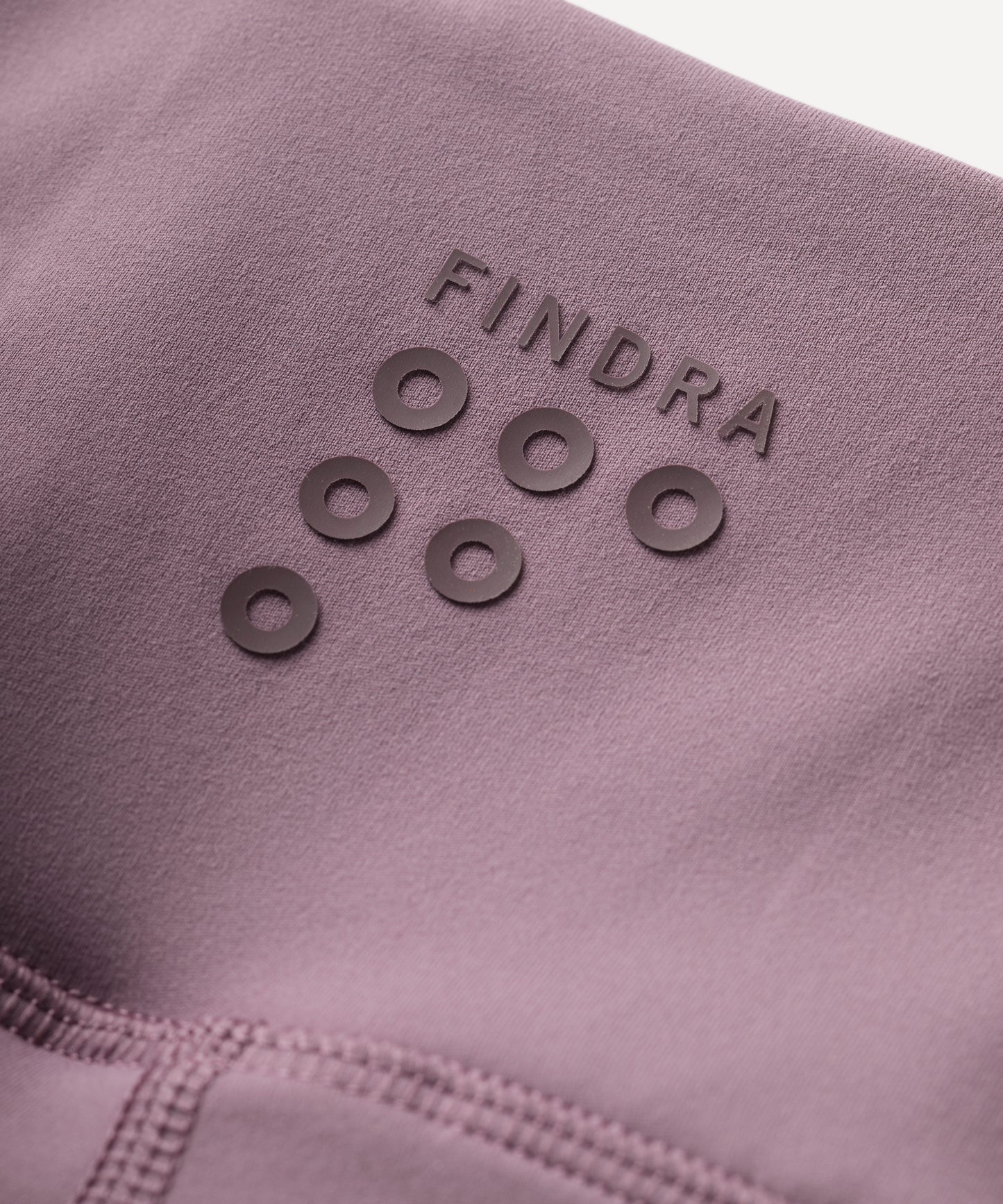 Close-up of a purple fabric with 'Findra' branding and circular patterns.