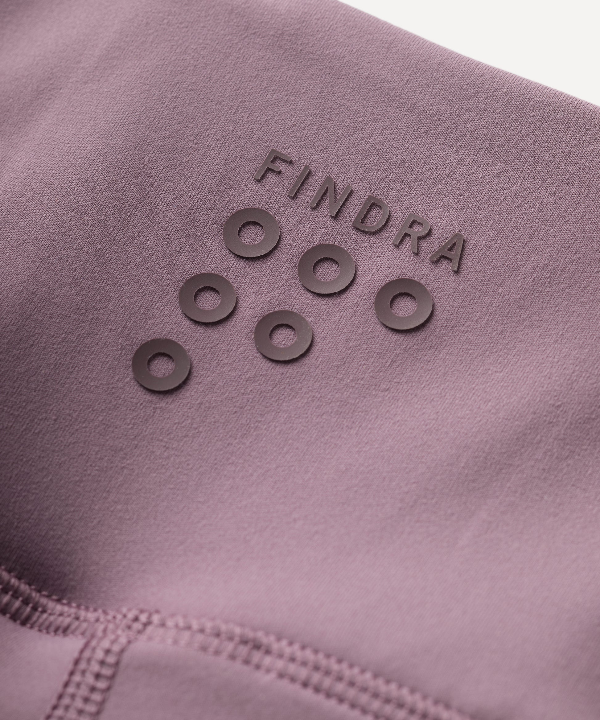 Close-up of a purple fabric with 'Findra' branding and circular patterns.
