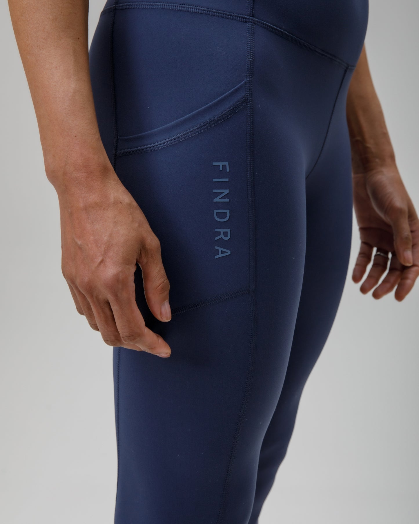 Navy blue leggings with 'FINDRA' branding on a light gray background