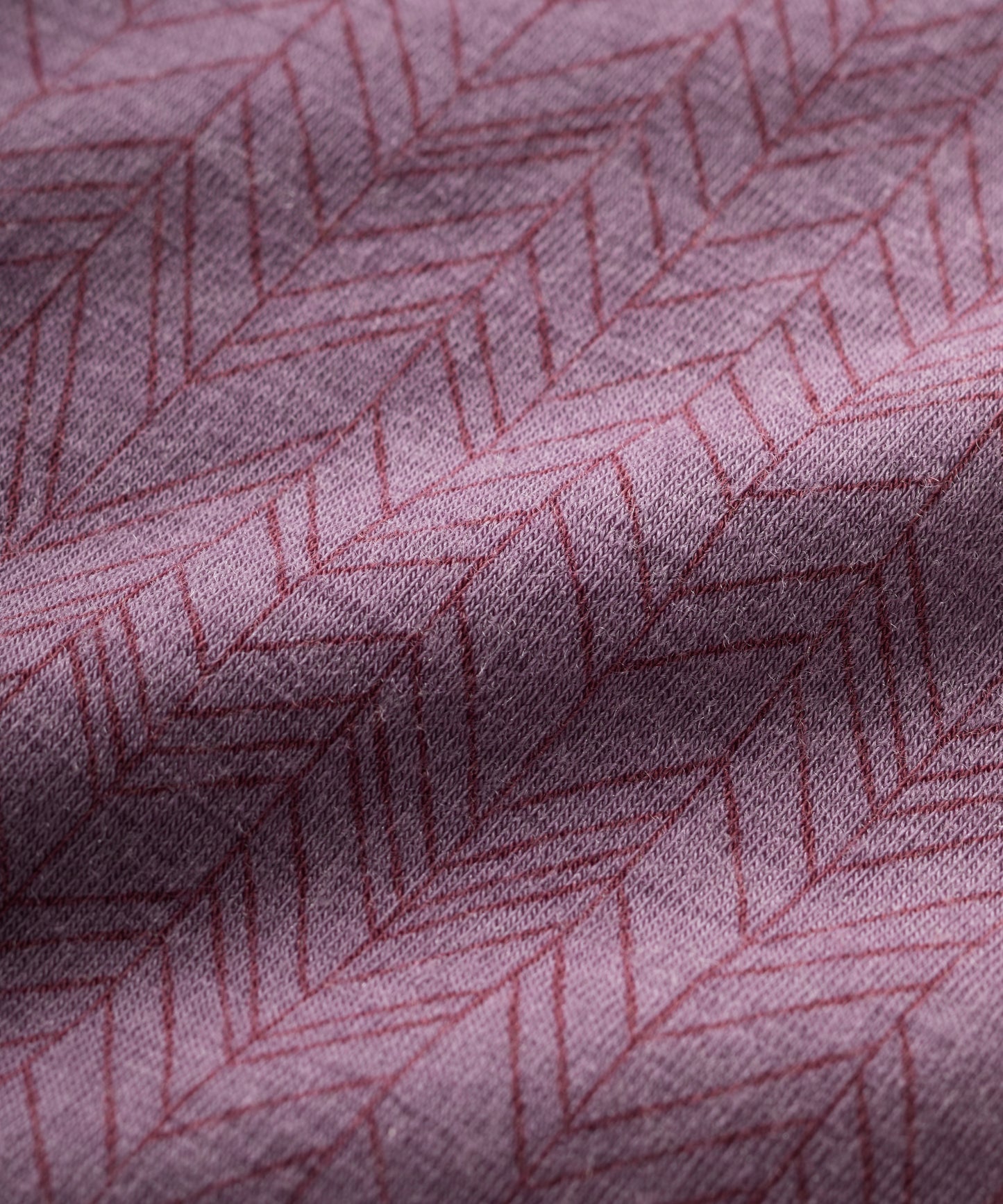 Close-up of purple merino fabric with a subtle geometric pattern
