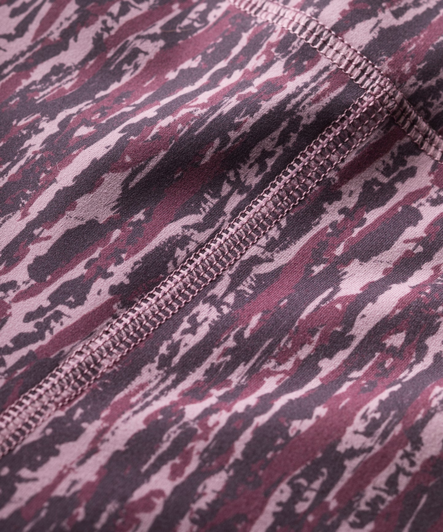 close up of purple patterned technical leggings showing flatlocked seams