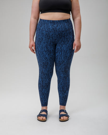 Person wearing blue patterned performance leggings on a white background