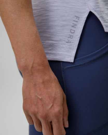 Person wearing a gray athletic shirt with 'FINDRA' branding, holding a blue object.