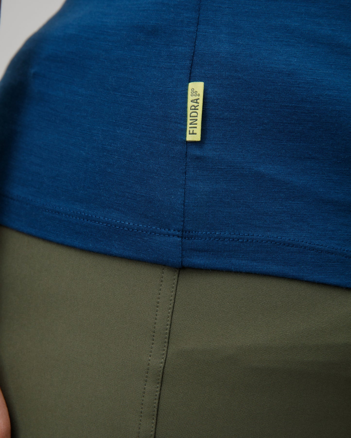 Close-up of a blue and green garment with a yellow findra brand label.