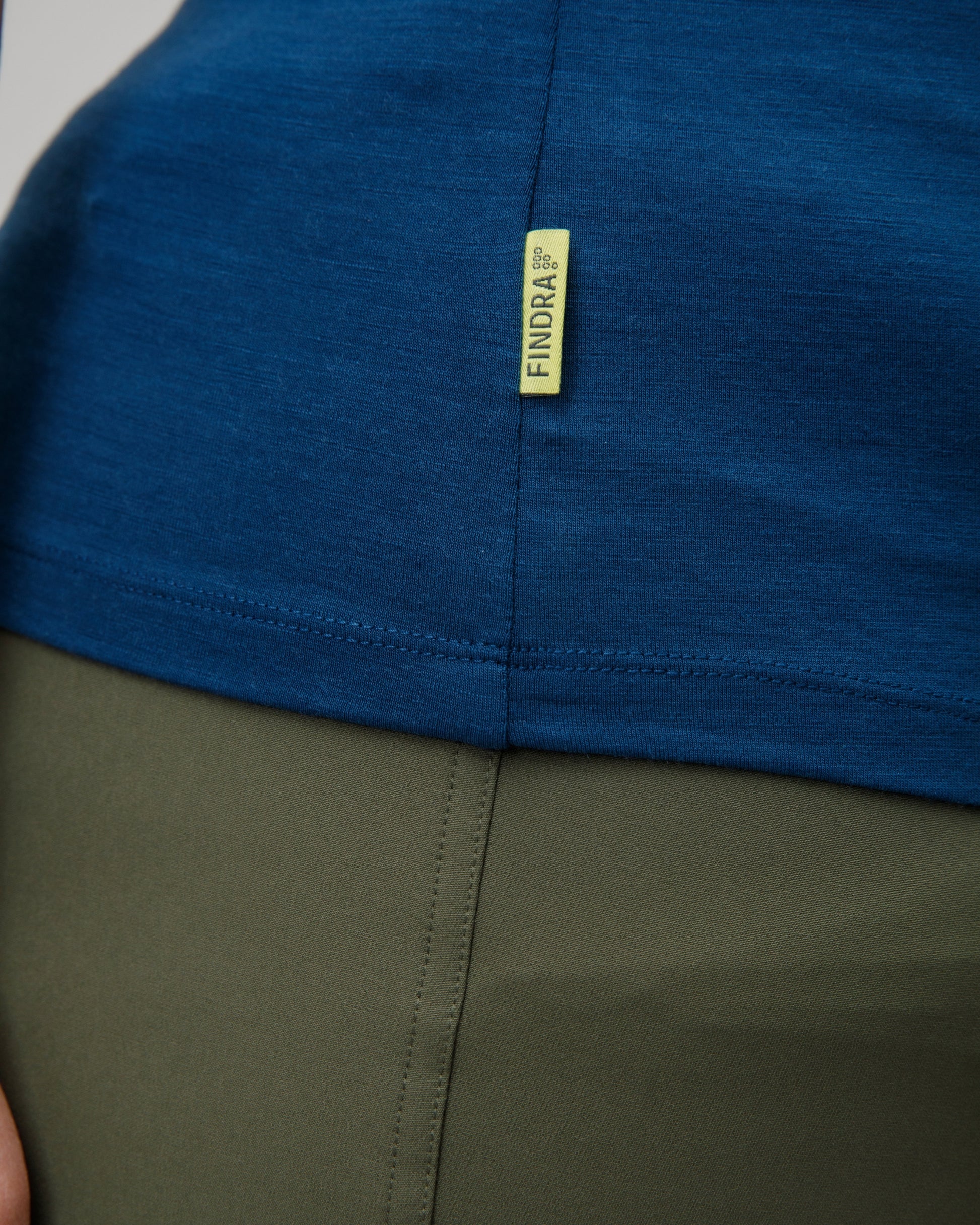 Close-up of a blue and green garment with a yellow findra brand label.