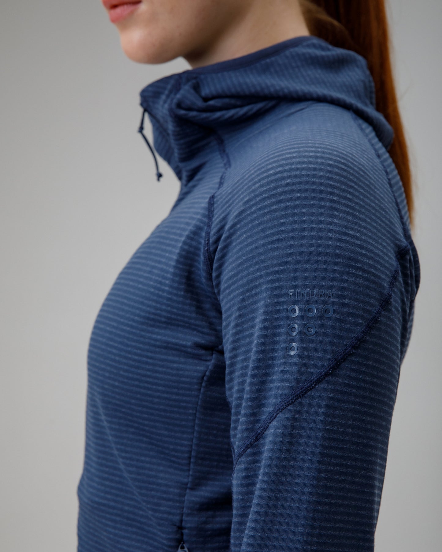 Person wearing a blue textured jacket on a plain background