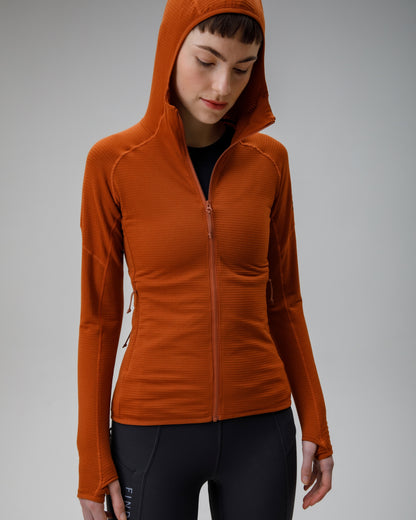 Person wearing an orange hooded jacket on a gray background