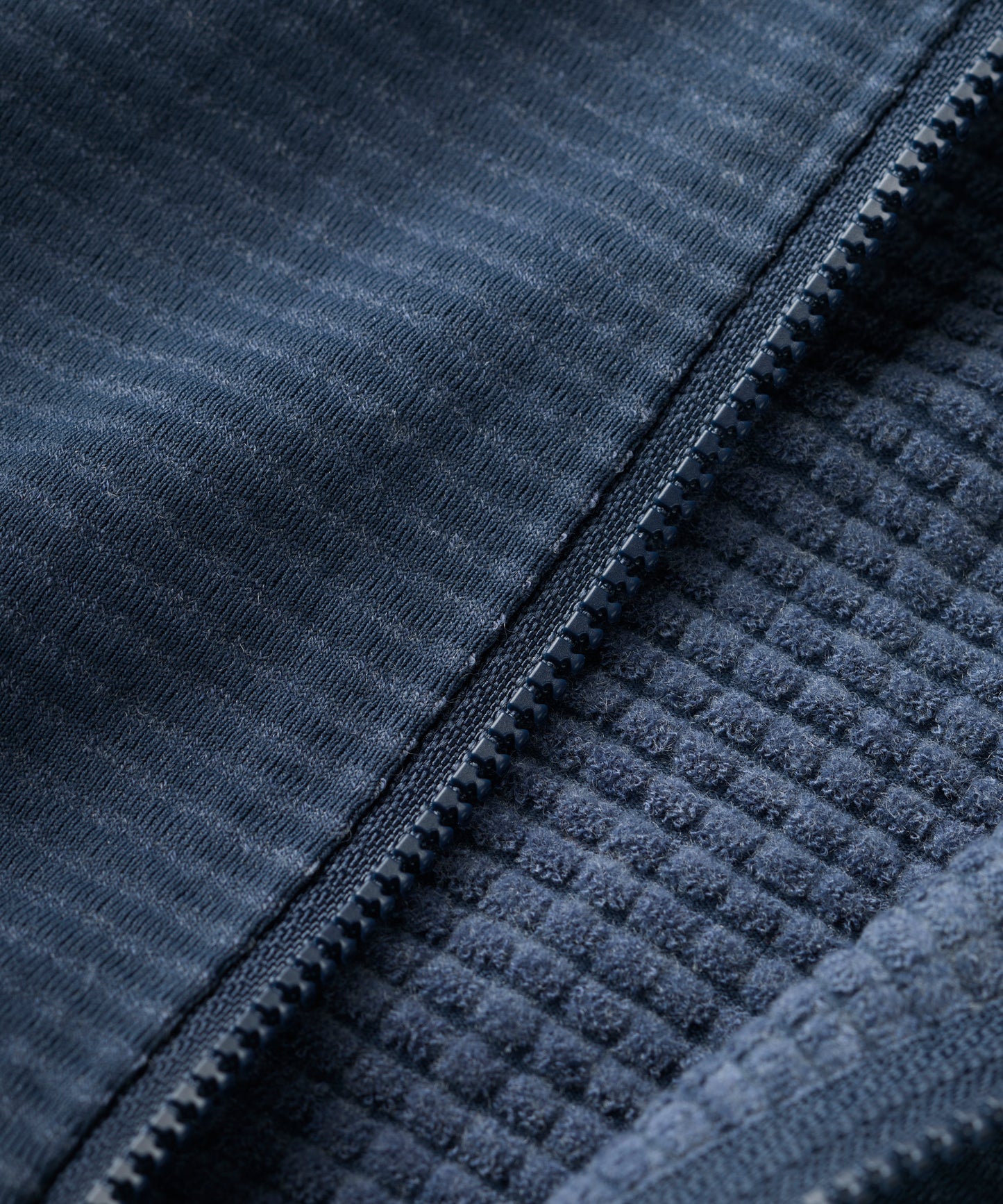 Close-up of a textured blue fabric with a zipper
