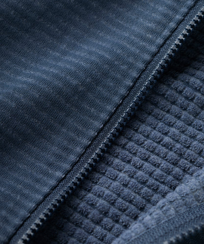 Close-up of a textured blue fabric with a zipper