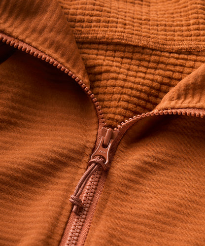 Close-up of a rust orange textured fabric with a zipper