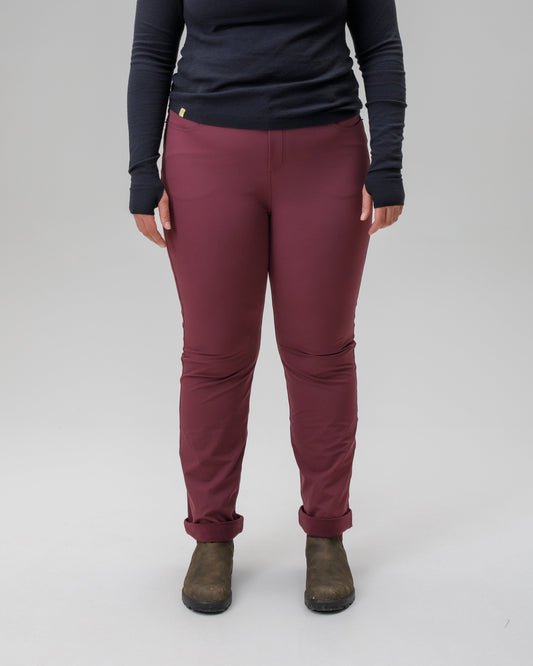 Person wearing a black long-sleeve top and maroon pants on a gray background