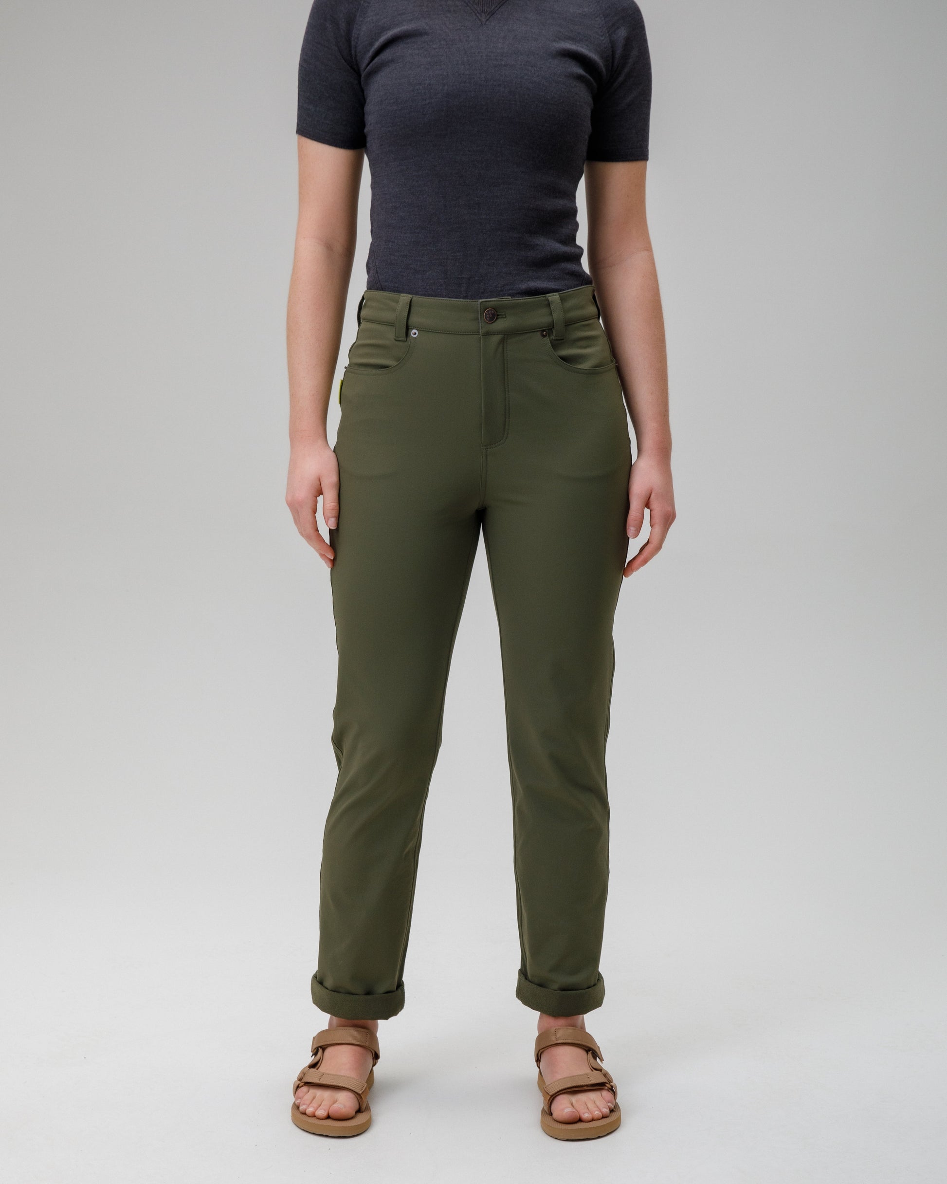 Person wearing green pants and a black top on a white background