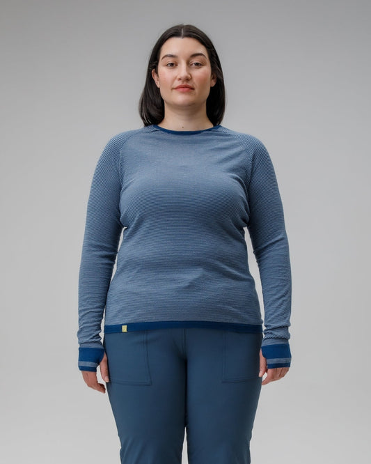 Person wearing a blue long-sleeve top and pants on a gray background