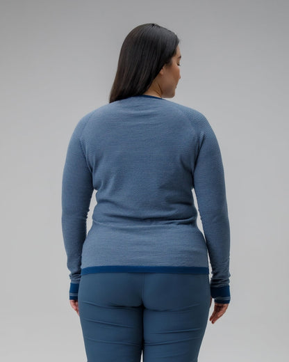 Person wearing a blue outfit standing against a plain background
