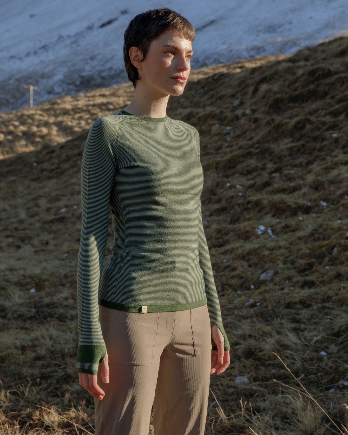 Woman in the outdoors wearing a FINDRA Striped Merino wool top and Millie technical trousers