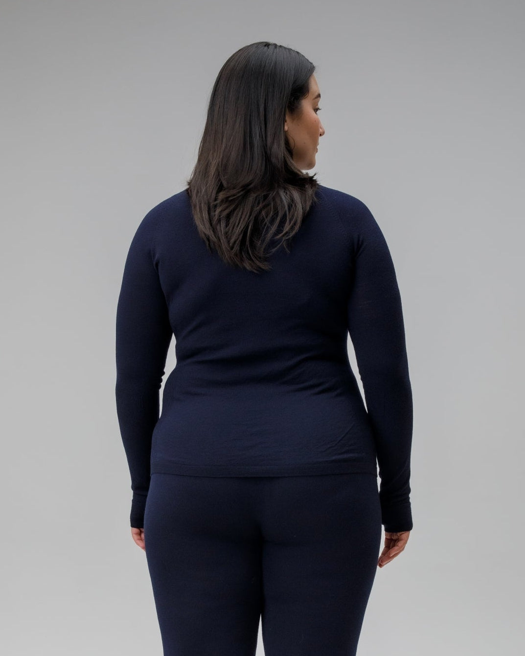 Person wearing a navy blue outfit on a plain background