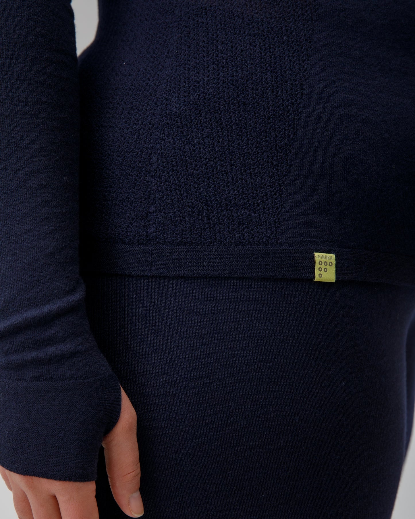 Navy blue garment with a small FINDRA yellow label on a light gray background