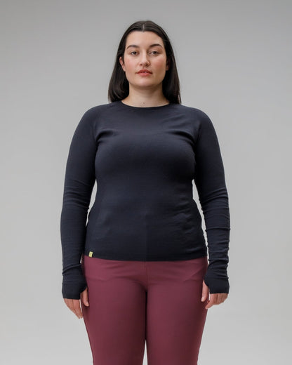 Person wearing a black long-sleeve shirt and maroon pants on a gray background