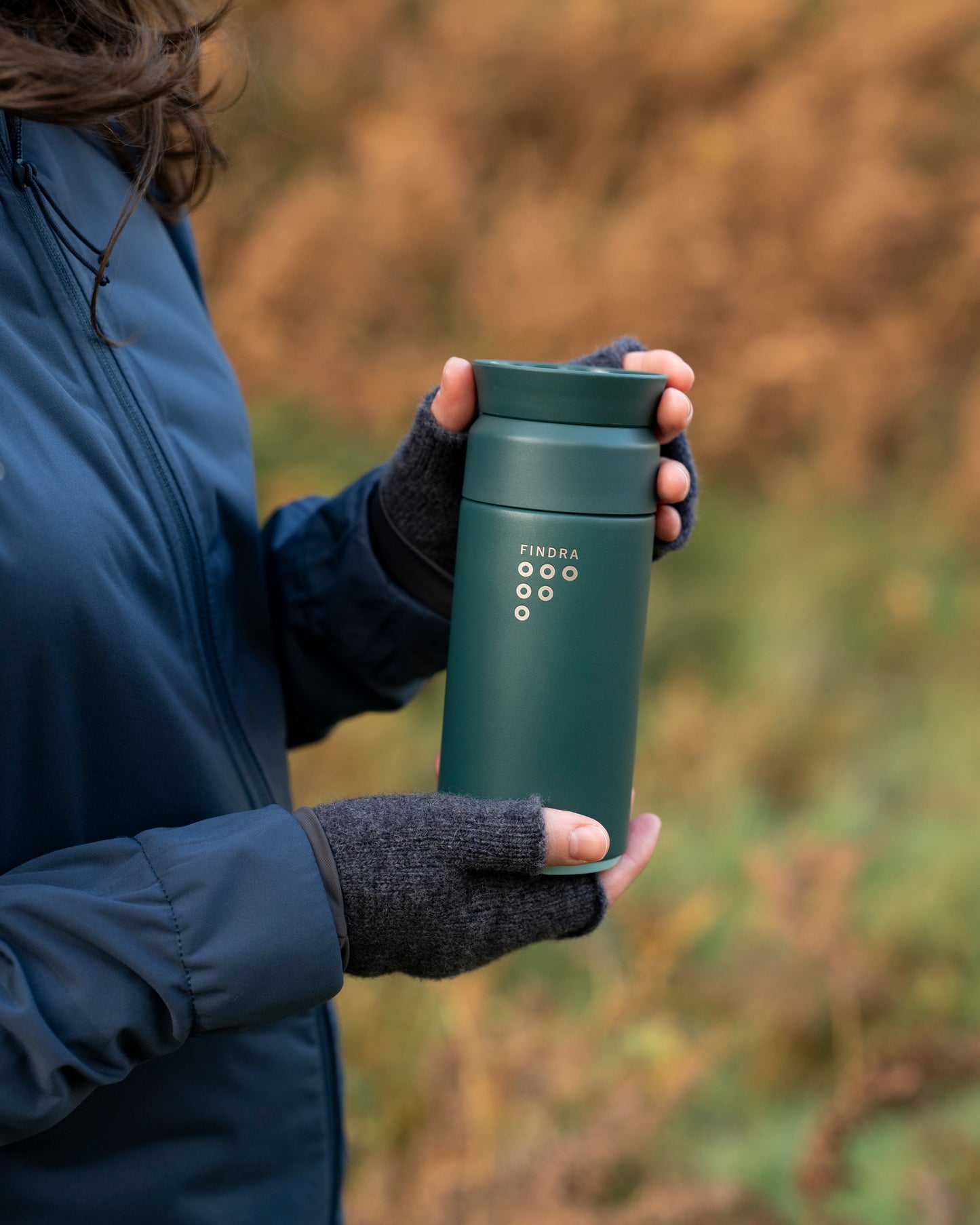 Image of the FINDRA and Ocean Bottle Brew flask being held by a women outdoors in the Autumn
