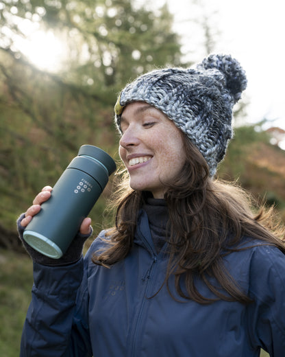 Image of an Ocean Bottle Brew Flask by FINDRA with a smiling woman in the outdoors enjoying a drink
