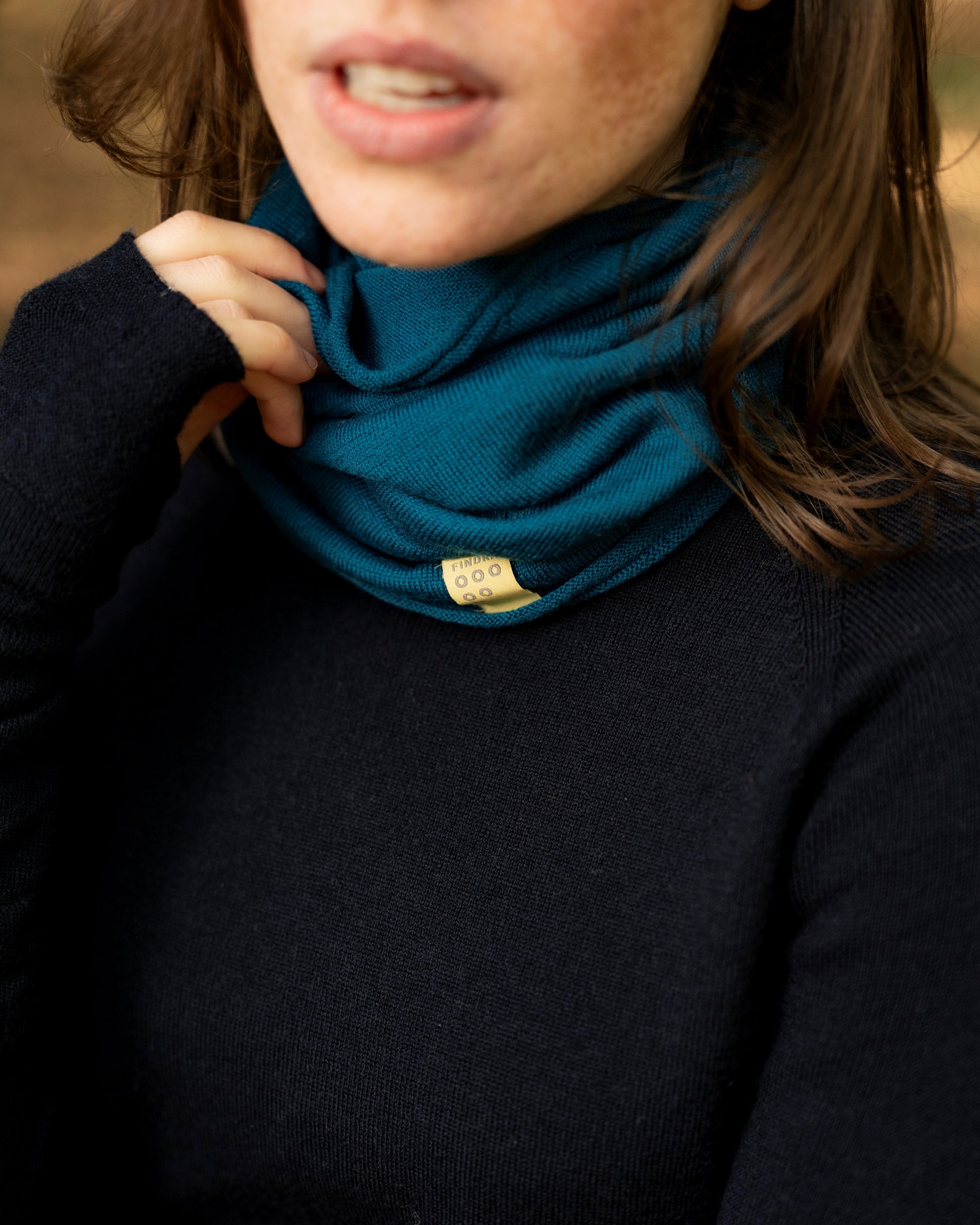 Woman wearng a Teal Merino wool neck warmer from FINDRA