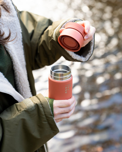 Women in the outdoors with her Ocean bottle and FINDRA Brew Flask in Sahara Red