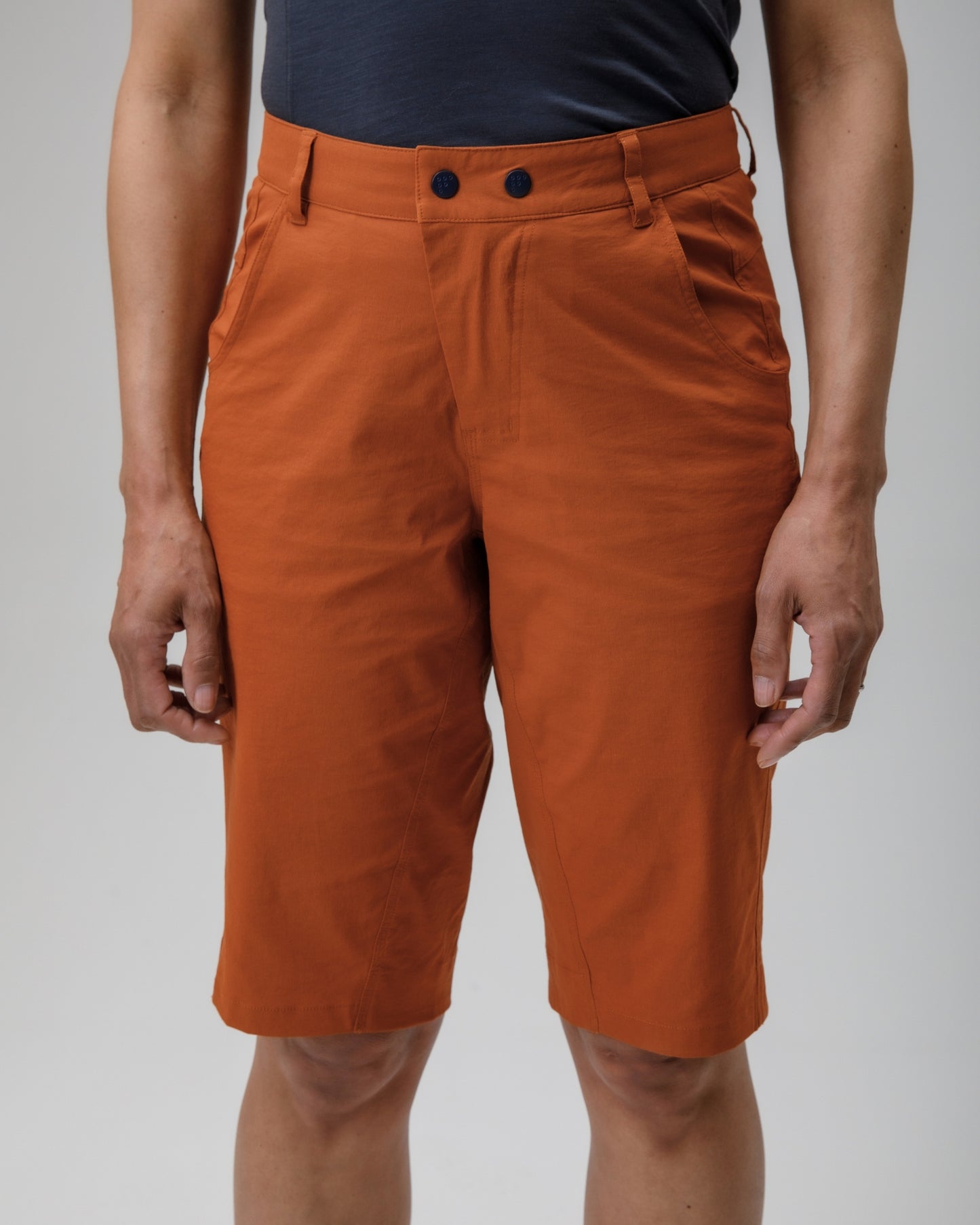 Orange shorts worn by a person on a plain background