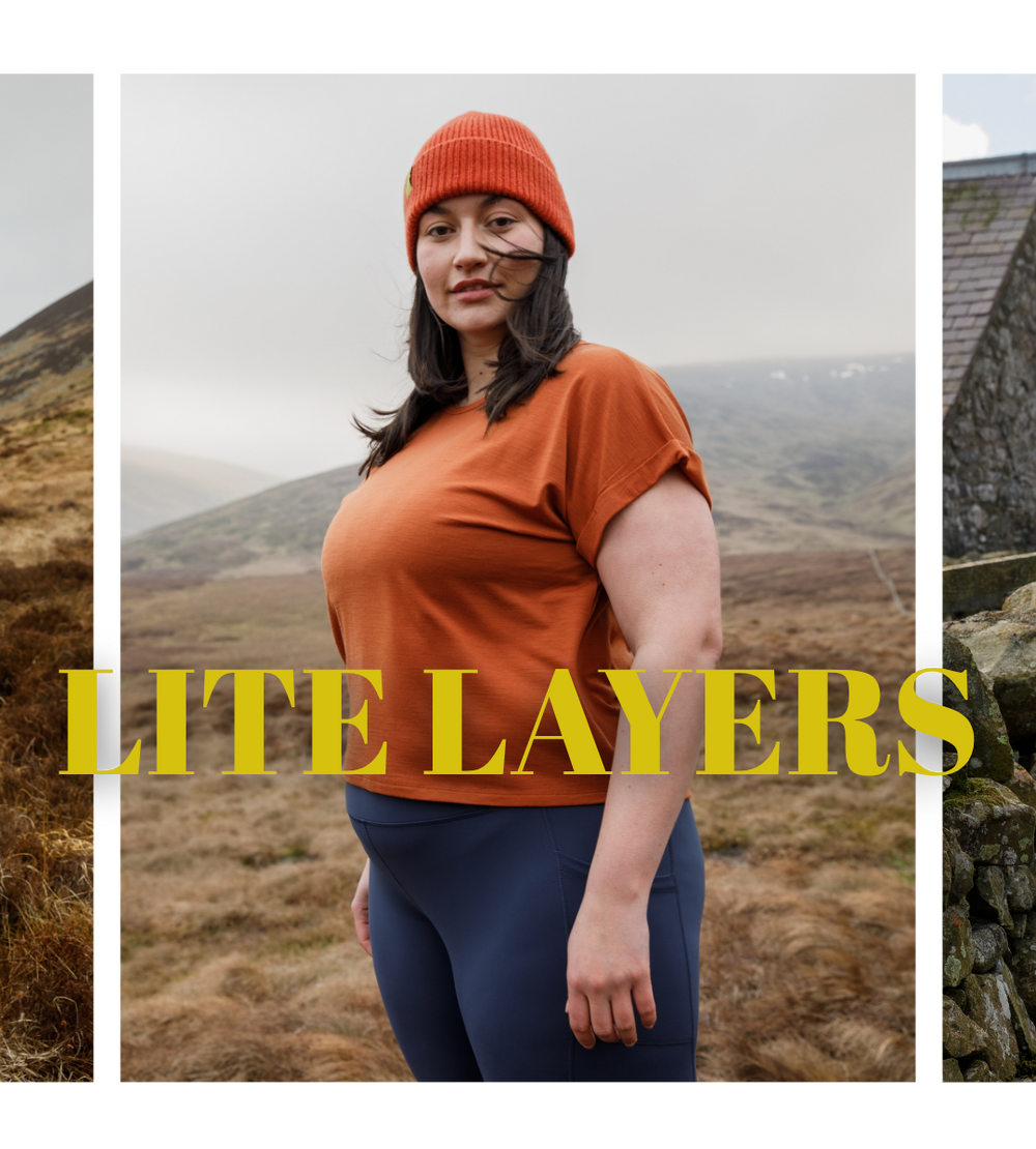 Person wearing orange top and blue leggings with 'Lite Layers' text in a mountainous landscape