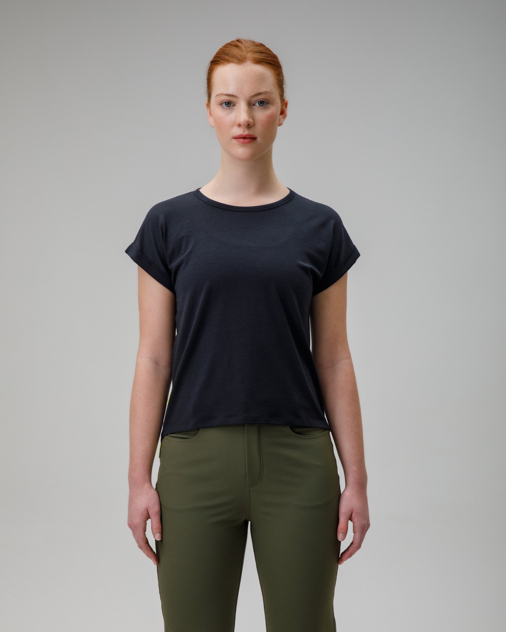 woman wearing a charcoal merino wool t-shirt on a grey background