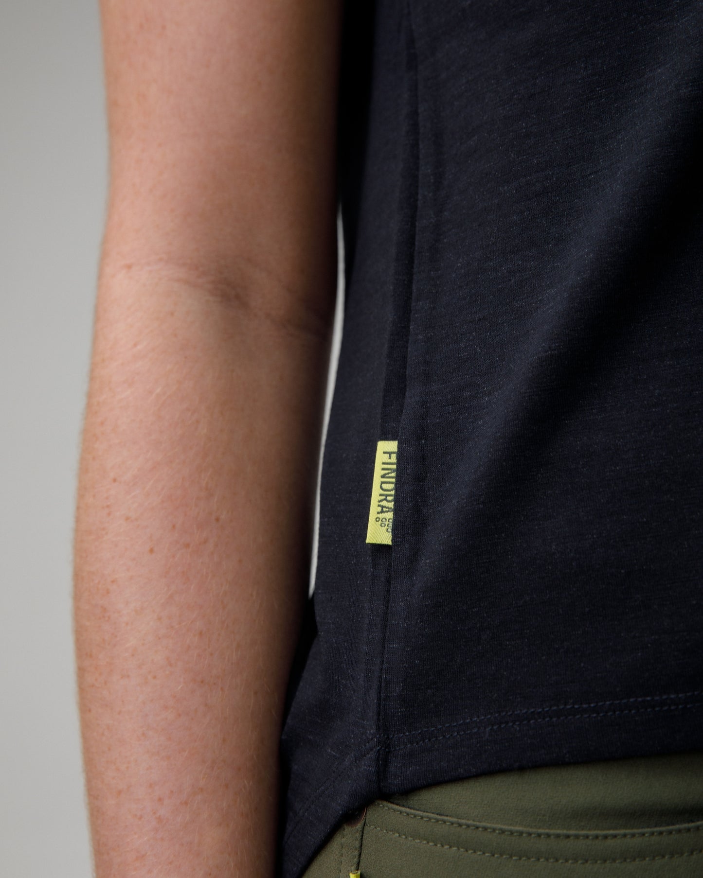 woman wearing a charcoal merino wool t-shirt on a grey background