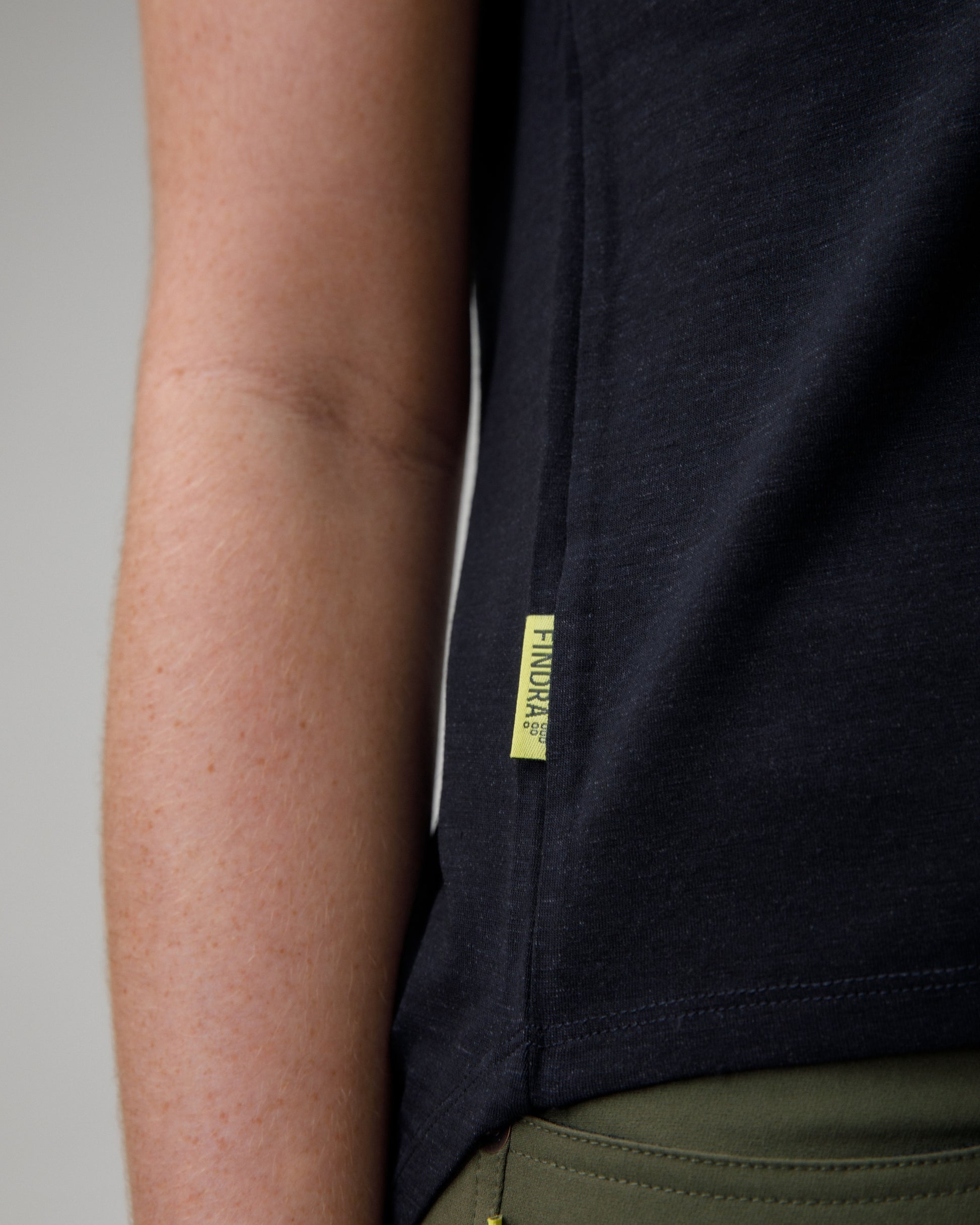 woman wearing a charcoal merino wool t-shirt on a grey background