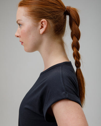 woman wearing a charcoal merino wool t-shirt on a grey background