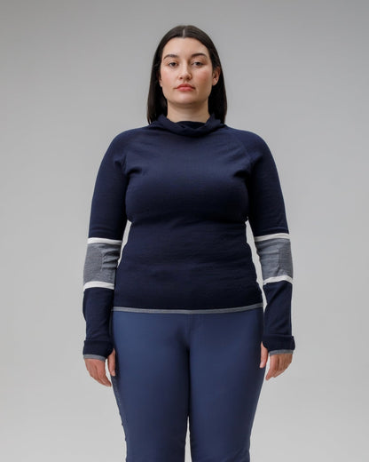 Person wearing a navy blue outfit with white and gray accents on a gray background
