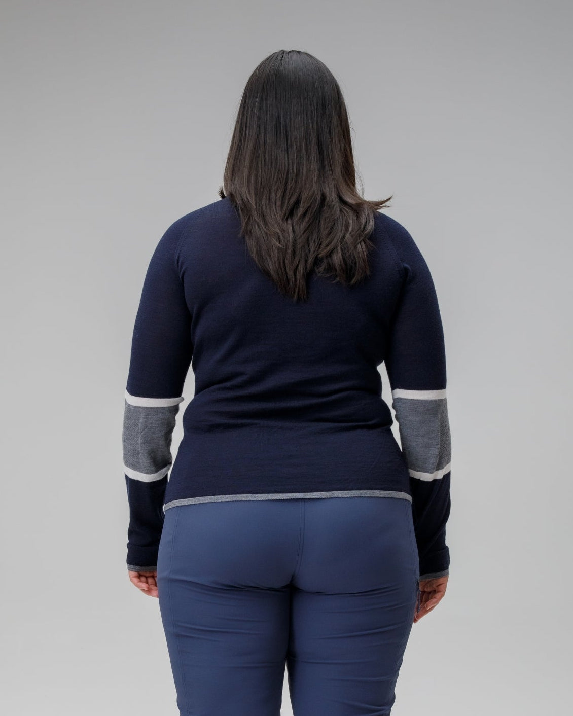 Person wearing a navy blue outfit with gray accents on a plain background