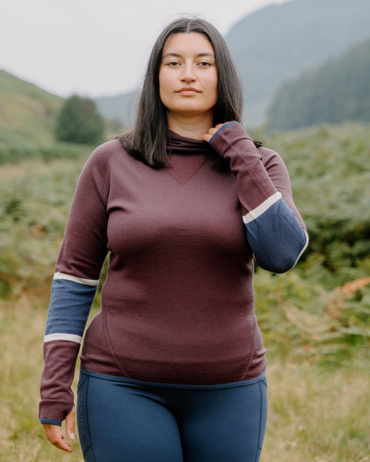 Woman in a mulberry FINDRA top with contrast sleeves in the outdoors. 