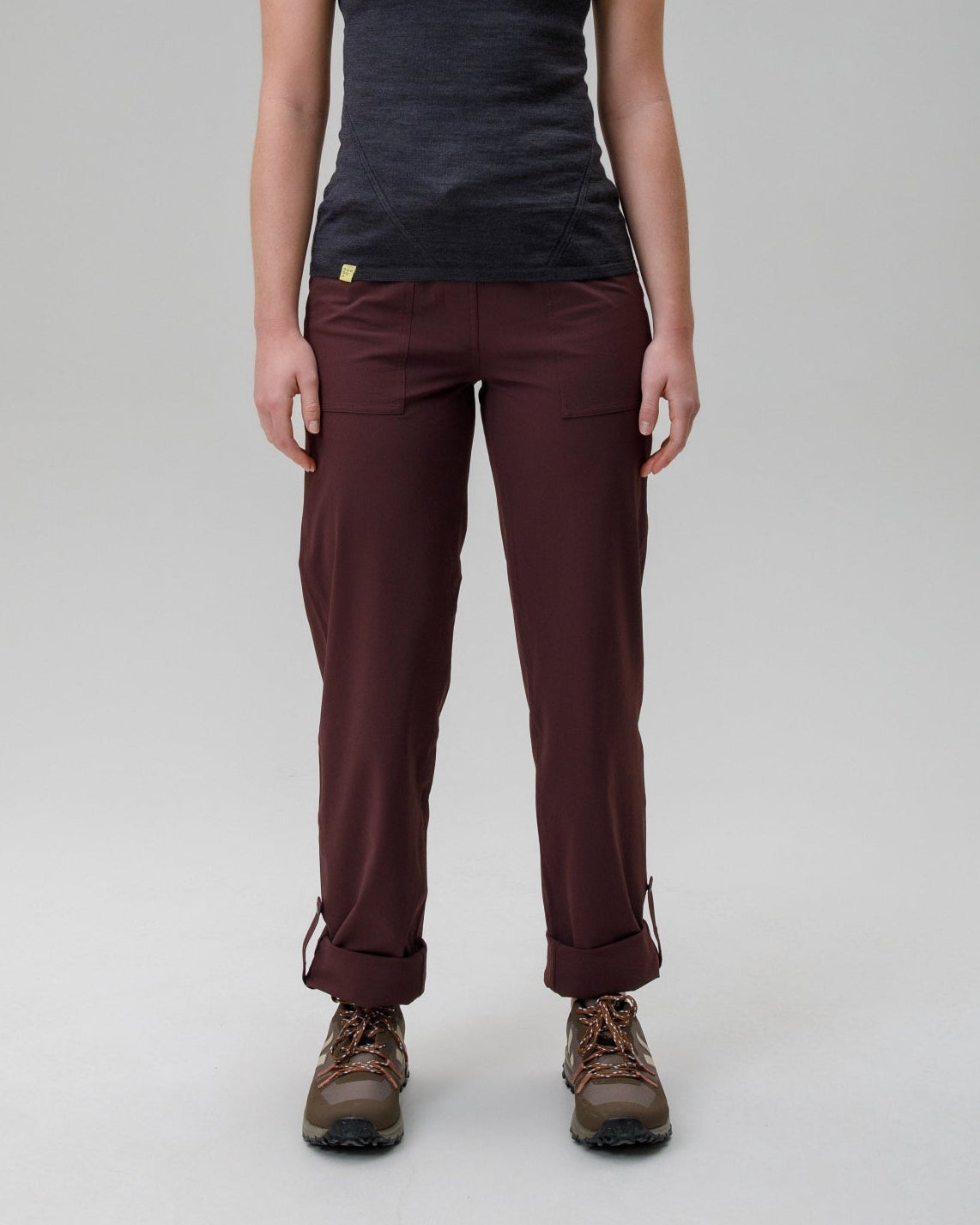 Person wearing a black t-shirt and maroon pants on a gray background