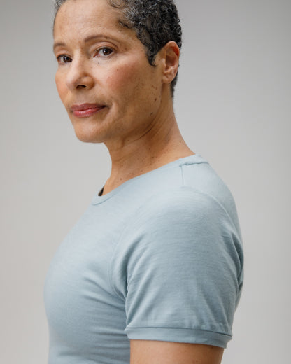 Woman wearing a light blue t-shirt against a plain background