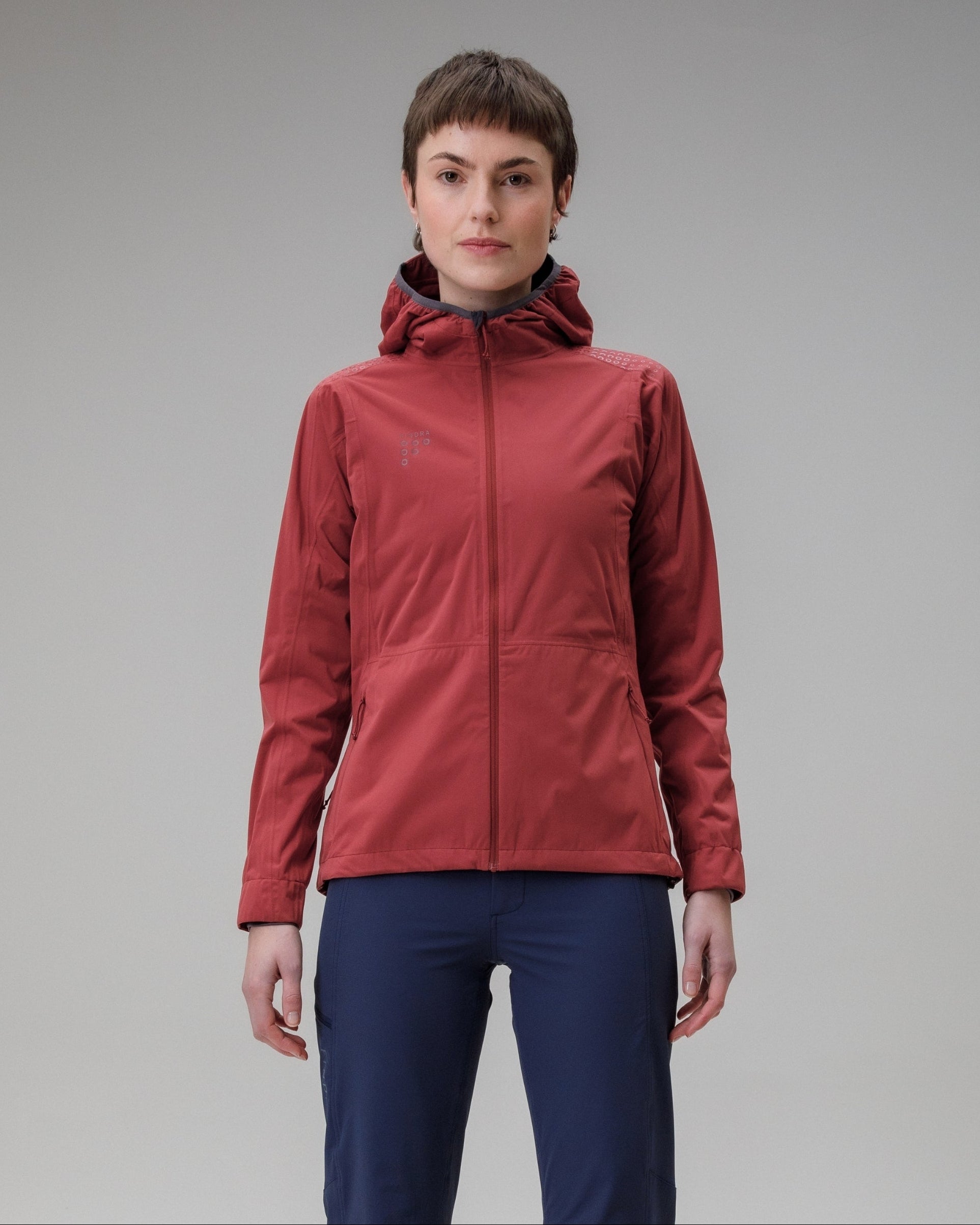 Person wearing a red jacket and blue pants on a gray background