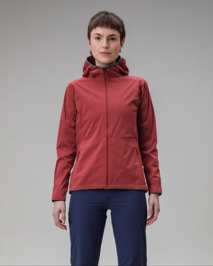 Person wearing a red jacket and blue pants on a gray background